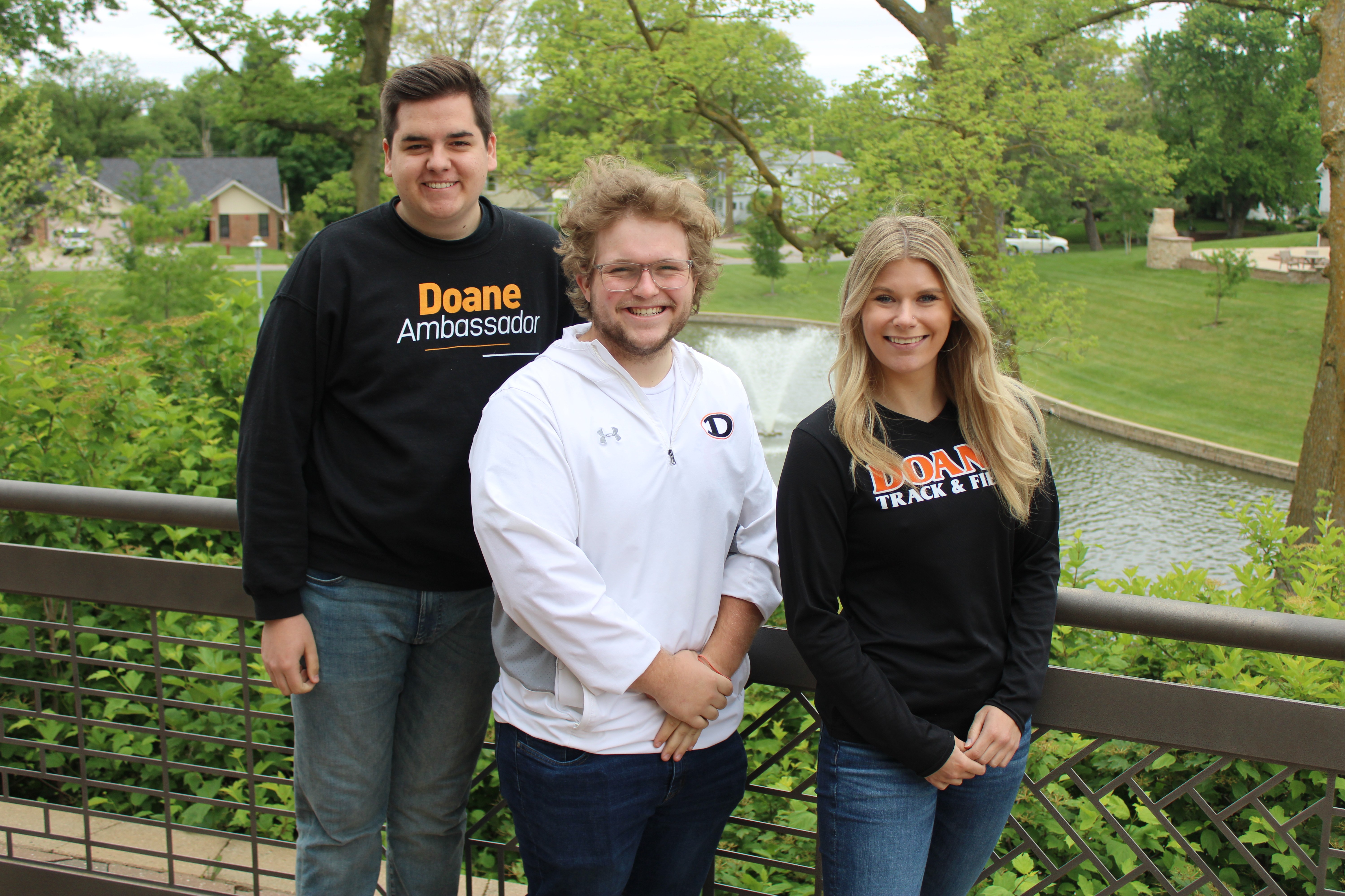 Three Doane ambassadors posing in front of a lake on Doane's Crete campus.